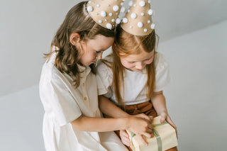 2 Children in Birthday Hats Opening Gift