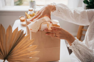 Women Opening Gift from Gift Bag in White Top